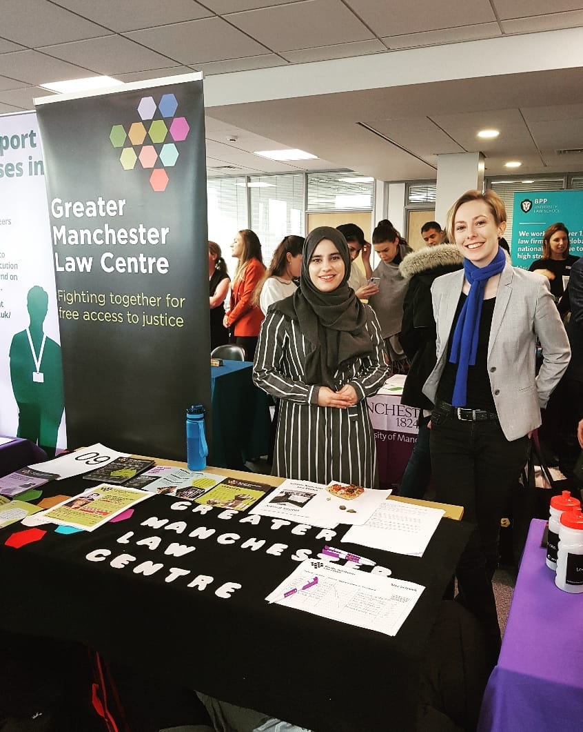 Image is a photo of GMLC's Arwa and Roz behind a GMLC stall at an event.