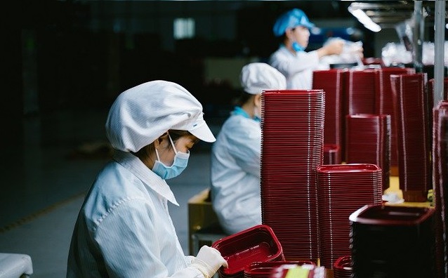 Image shows a worker in a food packaging factory.