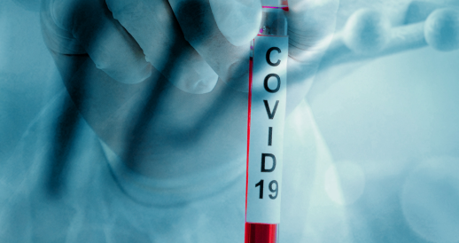 Image is a pale blue photo of a doctor's hand holding a tube marked 'Covid-19', edged in red.
