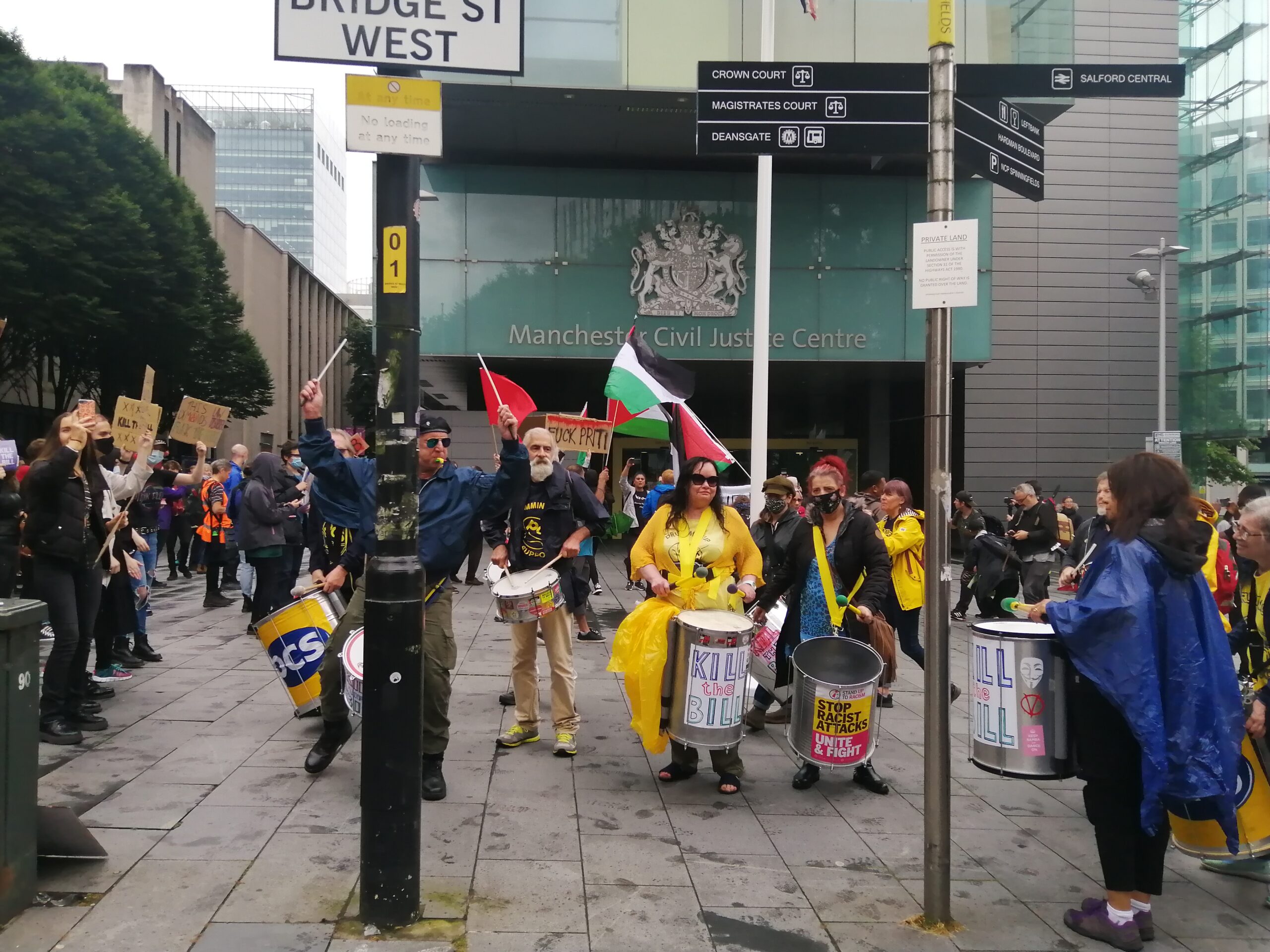 Photo shows the PCS Samba band outside the Manchester Civil Justice Centre playing drums, at a protest against the Police Bill 2021.