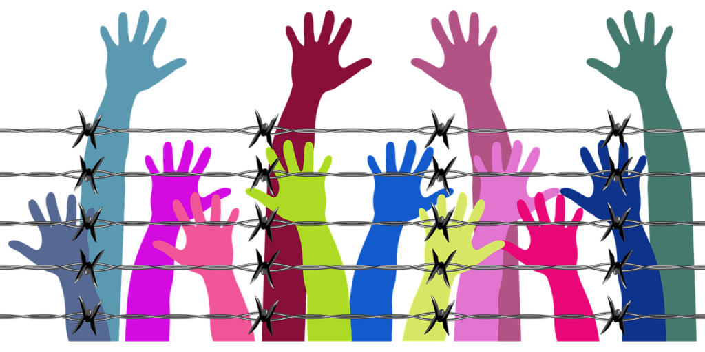 A cartoon of hands in a variety of bright colours reaching up over a foreground of barbed wire